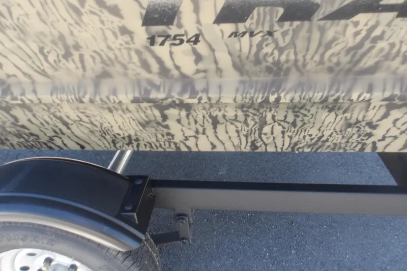 Slide: The Image of 2026 Tracker Grizzly 1648 SC boat with camouflage pattern and trailer wheel. - 7