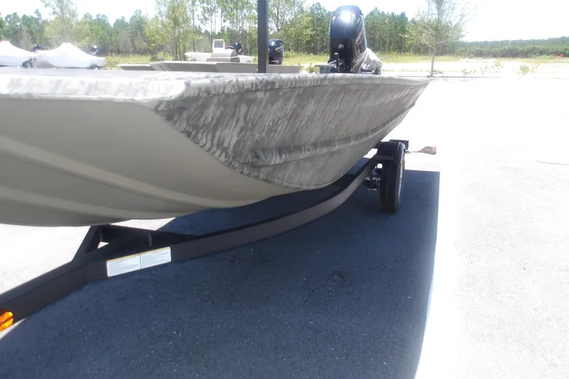 Slide: The Image of 2026 Tracker Grizzly 1648 SC boat on trailer, parked outdoors. - 11