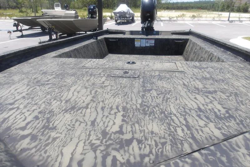 Slide: The Image of 2026 Tracker Grizzly 1648 SC boat with camouflage interior, parked outdoors. - 12