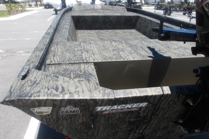 Slide: The Image of 2026 Tracker Grizzly 1648 SC boat with camo design in a parking lot. - 5
