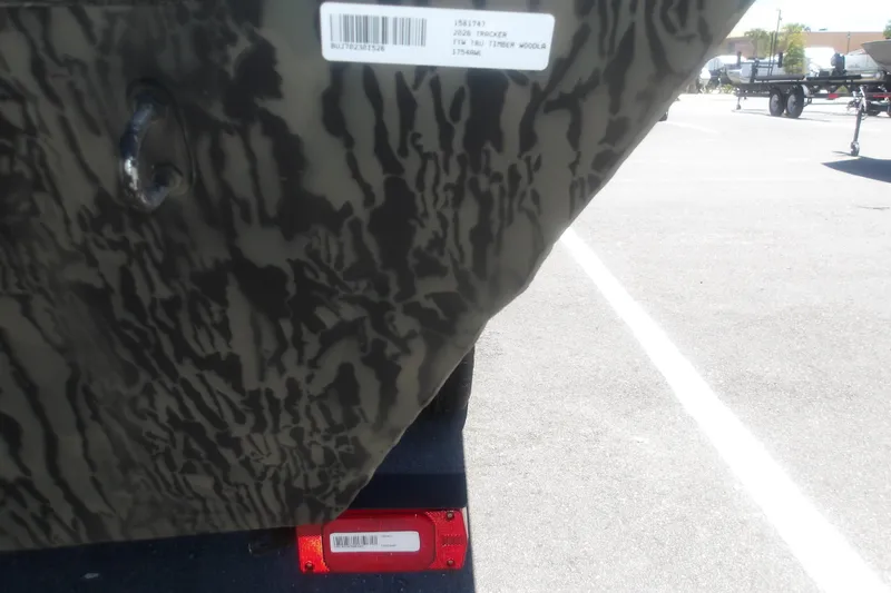 Slide: The Image of Camouflage-patterned 2026 Tracker Grizzly 1648 SC boat detail with barcode and trailer light. - 13