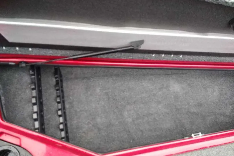 Slide: The Image of Open storage compartment of 2026 Nitro Z20 XL Pro boat, featuring red trim and carpeted interior. - 120