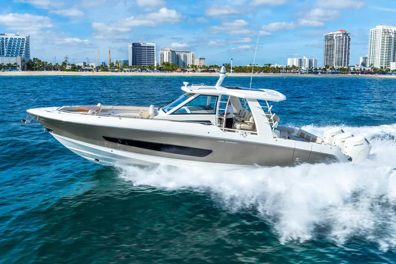 Slide: The Image of 2024 Boston Whaler 420 Outrage cruising on ocean near city skyline. - 17