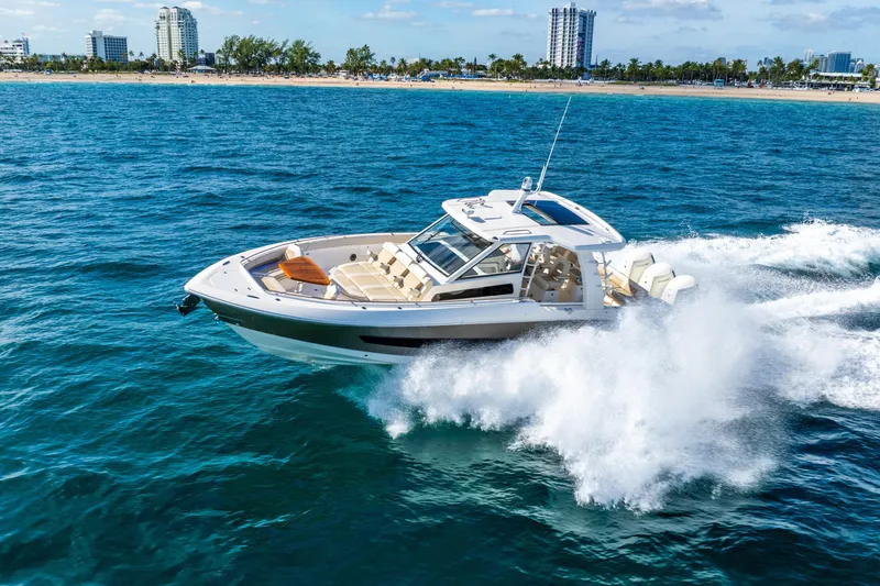 Slide: The Image of 2024 Boston Whaler 420 Outrage cruising on ocean near city skyline. - 19