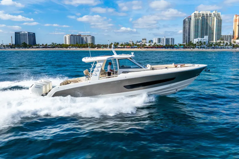 Slide: The Image of 2024 Boston Whaler 420 Outrage cruising on ocean near city skyline. - 21