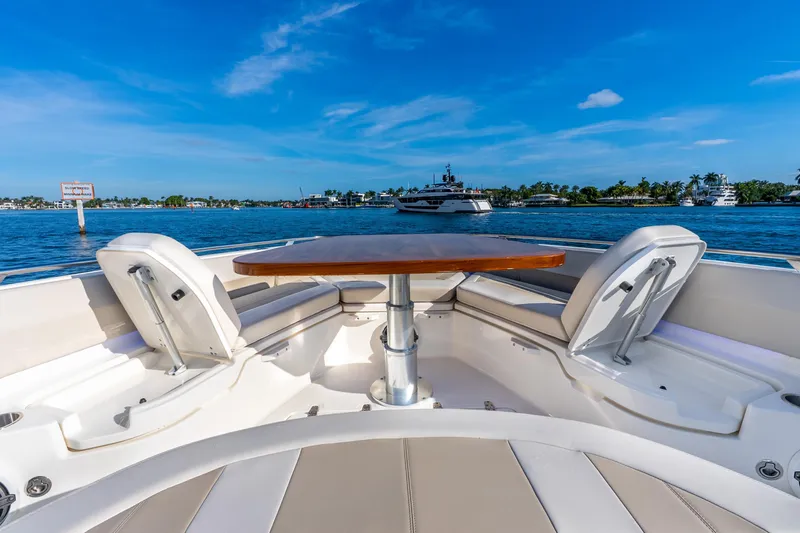 Slide: The Image of 2024 Boston Whaler 420 Outrage boat interior with seating and table, on a sunny day. - 27