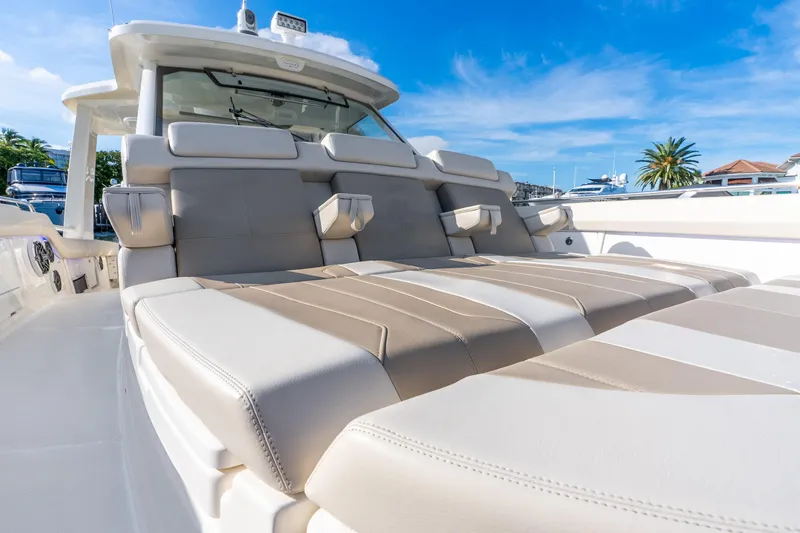 Slide: The Image of 2024 Boston Whaler 420 Outrage luxury seating under clear blue sky. - 29
