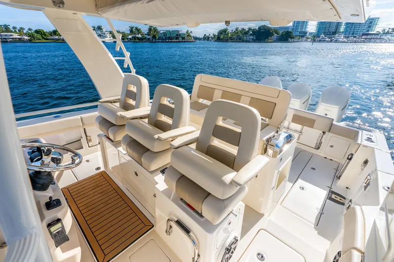 Slide: The Image of 2024 Boston Whaler 420 Outrage boat interior with luxurious seating and helm, overlooking serene waters. - 33