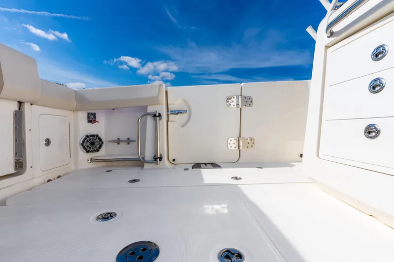Slide: The Image of 2024 Boston Whaler 420 Outrage deck with storage and seating under clear blue sky. - 42