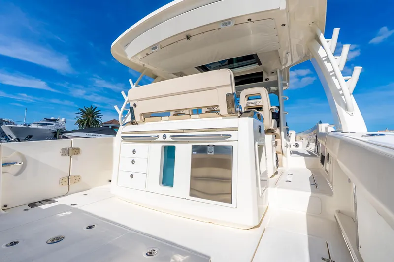 Slide: The Image of 2024 Boston Whaler 420 Outrage boat deck with seating and storage under clear blue sky. - 44