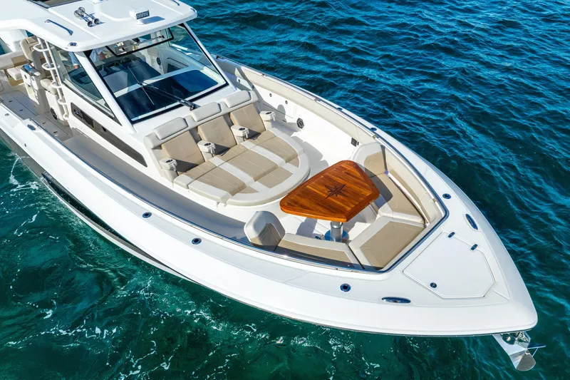 Slide: The Image of 2024 Boston Whaler 420 Outrage boat on clear blue water, showcasing luxury seating and design. - 7