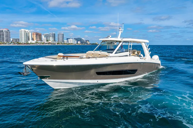 Slide: The Image of 2024 Boston Whaler 420 Outrage cruising on ocean with city skyline backdrop. - 8
