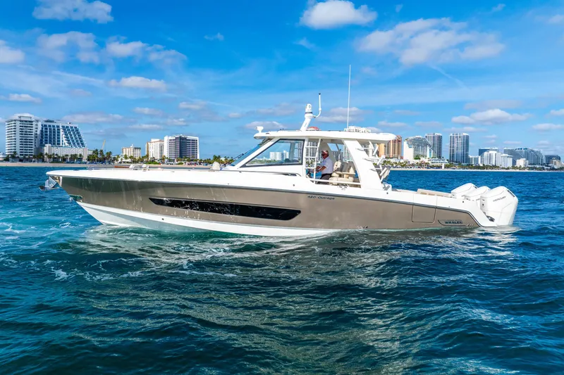 Slide: The Image of 2024 Boston Whaler 420 Outrage cruising on blue ocean near city skyline. - 9