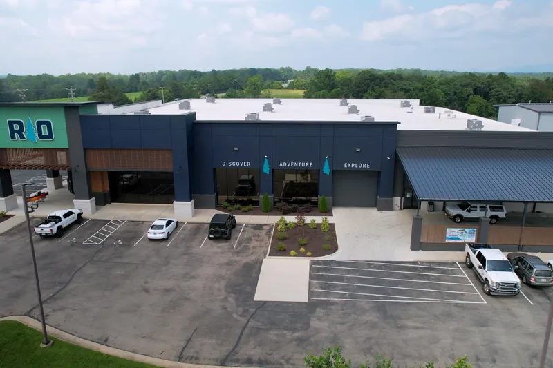 Slide: The Image of Aerial view of a modern building with "Discover Adventure Explore" signage, surrounded by parked vehicles. - 5