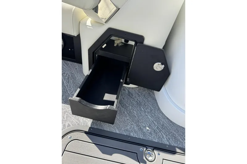 Slide: The Image of Open storage compartment in 2026 JC 24 SportToon TT boat interior. - 16