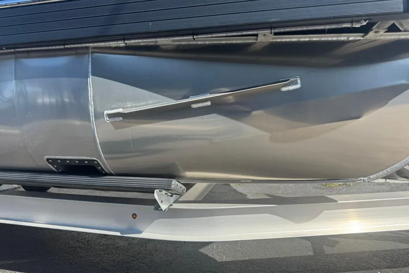 Slide: The Image of 2026 JC 24 SportToon TT pontoon boat hull on trailer, close-up view. - 8