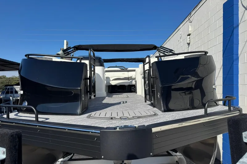 Slide: The Image of 2026 JC 24 SportToon TT pontoon boat, sleek design, docked under clear blue sky. - 10