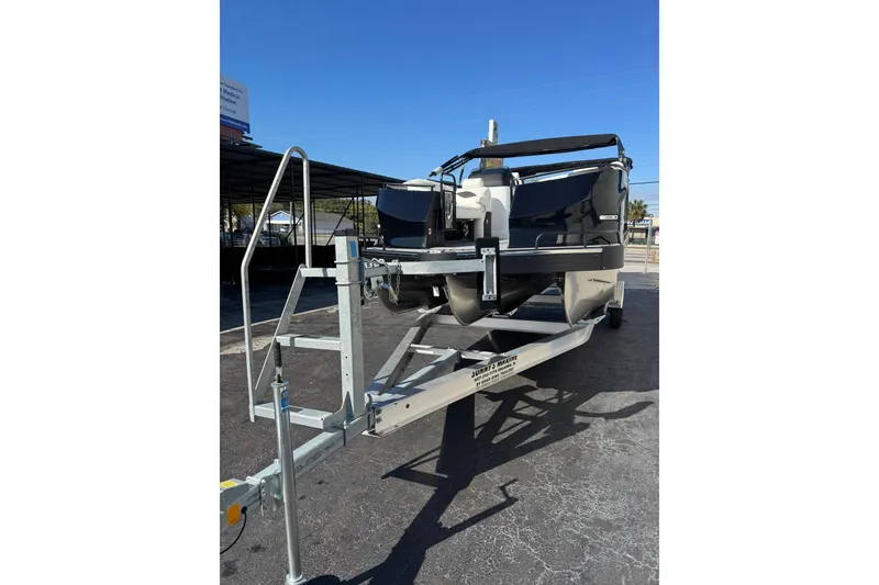Slide: The Image of 2026 JC 24 SportToon TT pontoon boat on trailer under clear blue sky. - 11