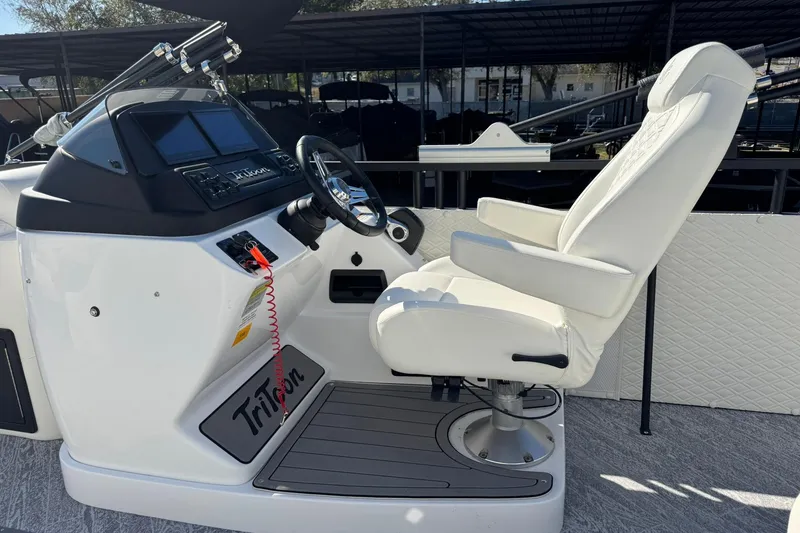 Slide: The Image of Captain's chair and helm of 2026 JC 24 SportToon TT boat, featuring modern controls. - 20
