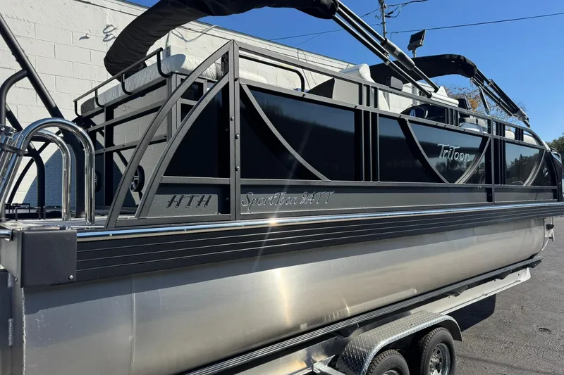 Slide: The Image of 2026 JC 24 SportToon TT pontoon boat with sleek black design on trailer. - 22