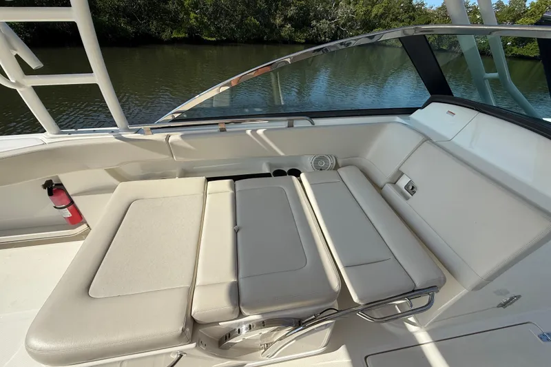 Slide: The Image of 2018 Boston Whaler 270 Vantage interior with beige seating and scenic water view. - 10