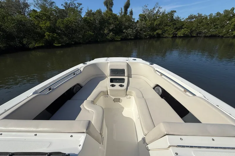 Slide: The Image of 2018 Boston Whaler 270 Vantage boat interior with cushioned seating, on calm water. - 11
