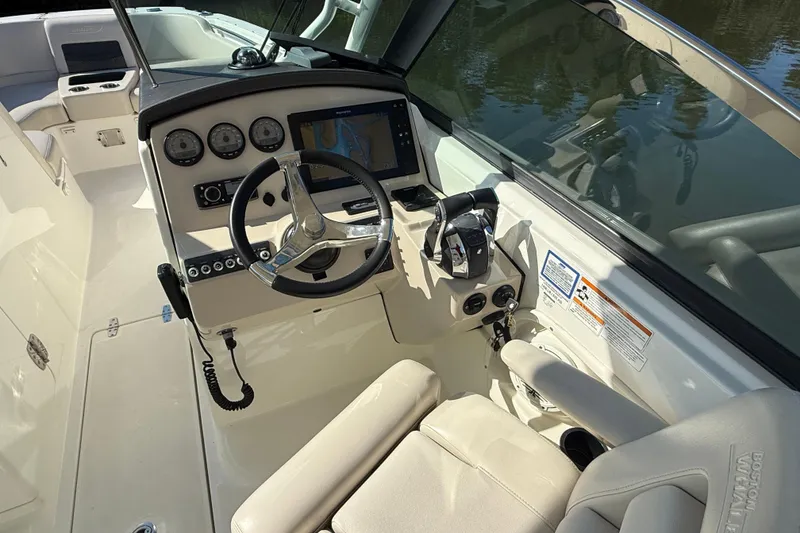 Slide: The Image of 2018 Boston Whaler 270 Vantage boat cockpit with steering wheel and navigation system. - 13