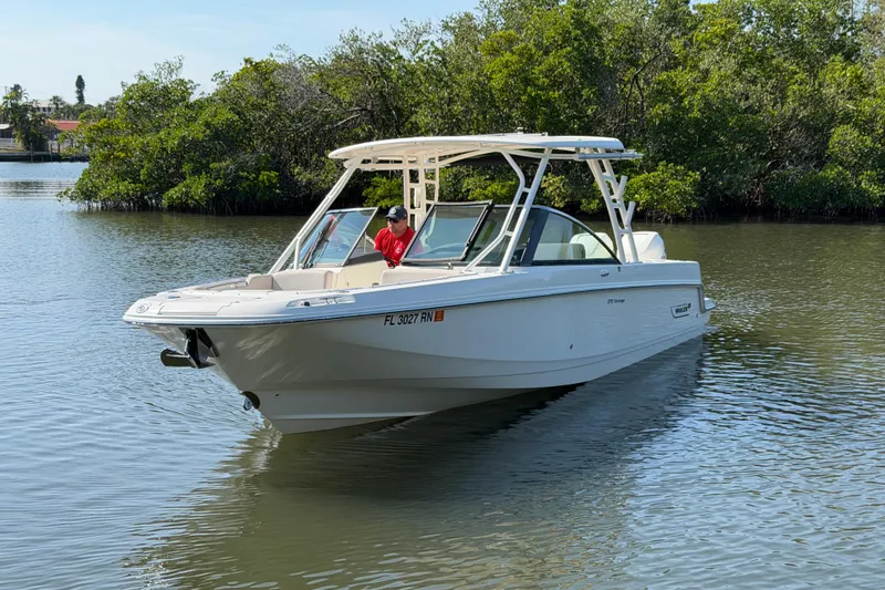 Slide: The Image of 2018 Boston Whaler 270 Vantage boat on calm water near lush greenery. - 4