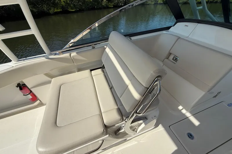 Slide: The Image of 2018 Boston Whaler 270 Vantage boat interior with cushioned seating and fire extinguisher. - 9