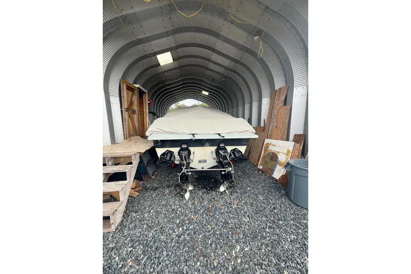 Slide: The Image of 1988 Thunderbird Formula 311 SR1 boat stored in a metal shed, covered and secured. - 10