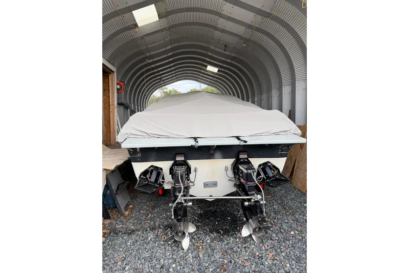 Slide: The Image of 1988 Thunderbird Formula 311 SR1 boat in storage, covered, with dual outboard motors. - 12