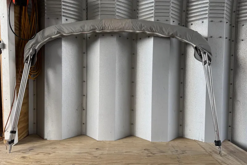 Slide: The Image of Gray bimini top for 1988 Thunderbird Formula 311 SR1, displayed against a corrugated metal wall. - 14