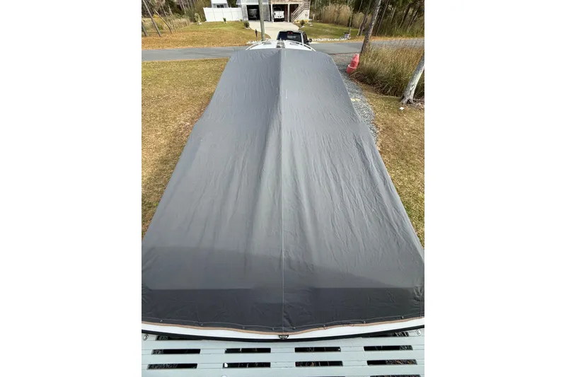 Slide: The Image of 1988 Thunderbird Formula 311 SR1 boat covered, parked outdoors on grass. - 16