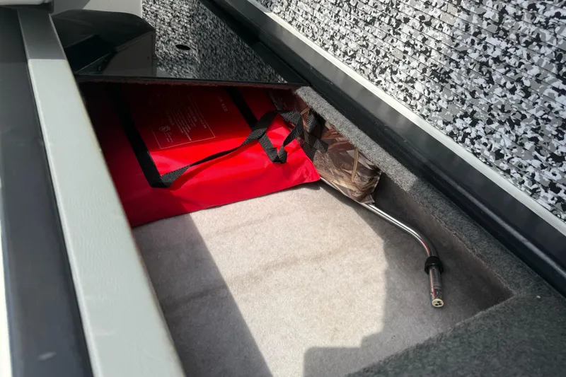 Slide: The Image of Storage compartment in a 1988 Thunderbird Formula 311 SR1 boat with red bag and tools. - 23