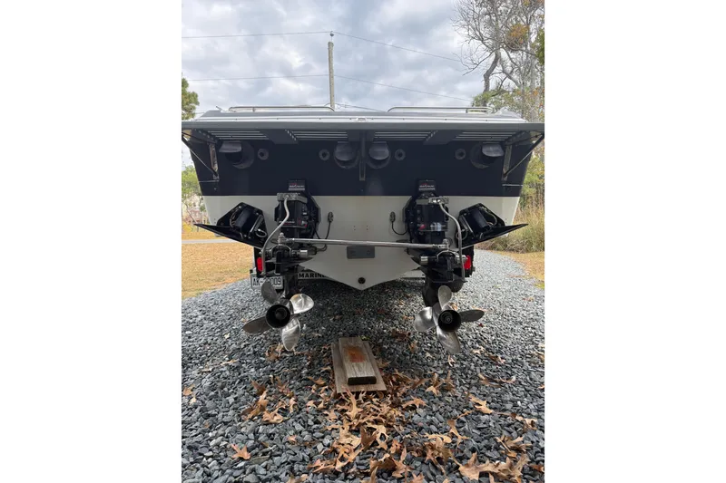 Slide: The Image of 1988 Thunderbird Formula 311 SR1 boat with dual outboard motors on gravel. - 6