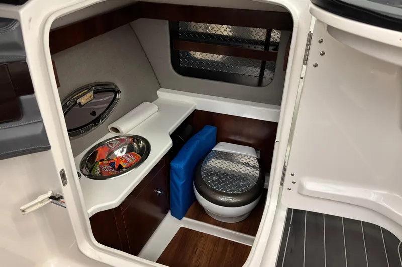 Slide: The Image of 2018 Chaparral 287 SSX boat interior with compact bathroom and amenities. - 13