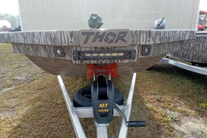 Slide: The Image of 2026 Thor 1754 Swamp Hammer boat on trailer, featuring camo design and LED lights. - 14