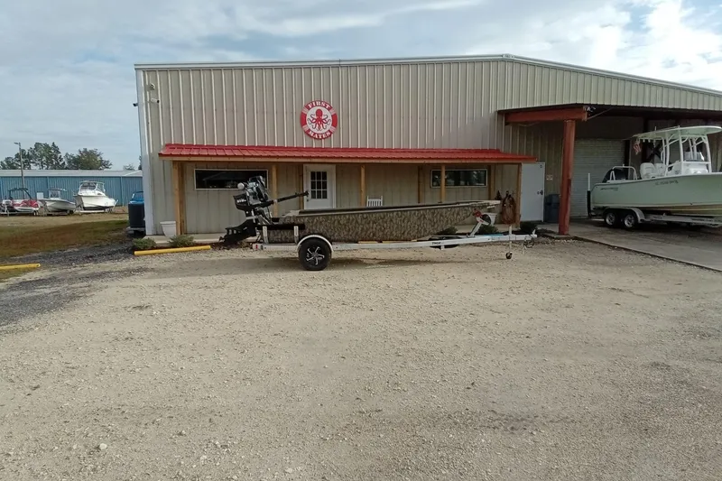 Slide: The Image of 2026 Thor 1754 Swamp Hammer boat parked outside a metal building with red roof. - 18