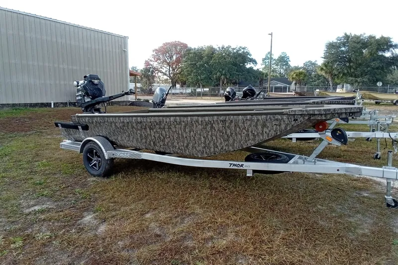 Slide: The Image of 2026 Thor 1754 Swamp Hammer boat on trailer, parked outdoors. - 3