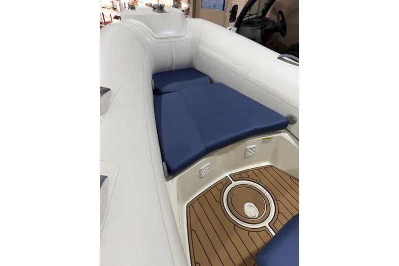 Slide: The Image of 2019 Brig Eagle 5 boat interior with blue seating and teak-style flooring. - 3