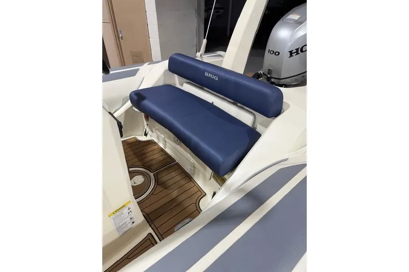 Slide: The Image of 2019 Brig Eagle 5 boat interior with blue seating and Honda outboard motor. - 5