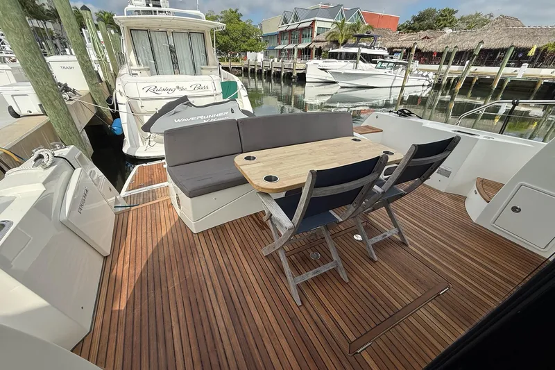 Slide: The Image of Outdoor seating area on 2017 Prestige 500S yacht with wooden deck and marina view. - 14