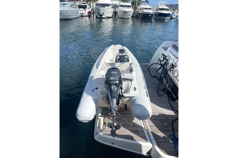 Slide: The Image of A 2017 Prestige 500S yacht docked with a small inflatable boat attached. - 32