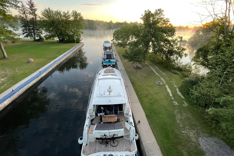 Slide: The Image of 2017 Prestige 500S yacht docked on a serene river at sunrise. - 4
