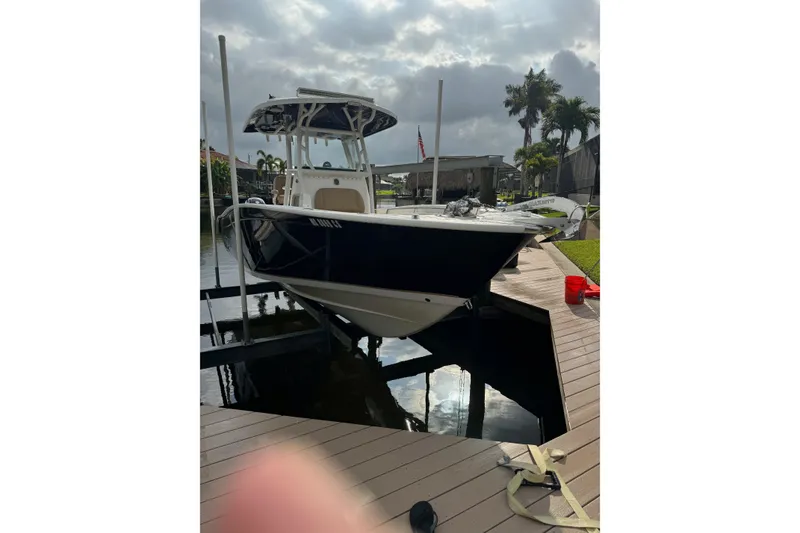 Slide: The Image of 2019 Cape Horn 27 XS boat docked on a sunny day, surrounded by palm trees. - 27