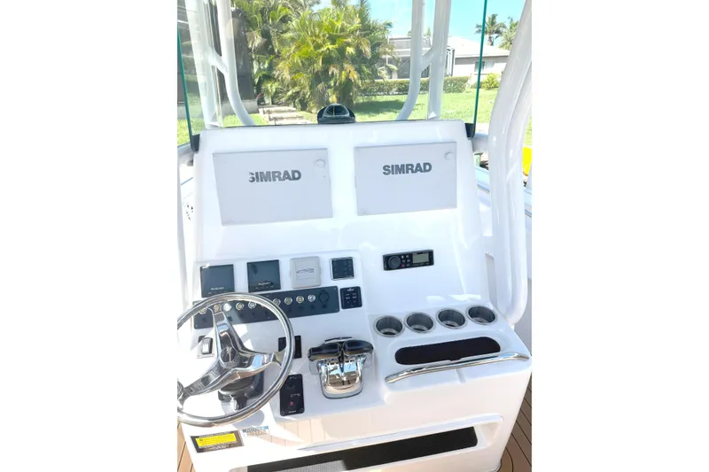 Slide: The Image of 2019 Cape Horn 27XS boat console with Simrad displays and steering wheel. - 7