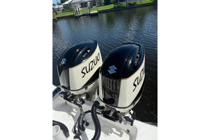 Slide: The Image of Twin Suzuki outboard engines on a 2019 Cape Horn 27XS boat by a canal. - 8