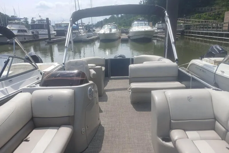 Slide: The Image of 2023 Cypress Cay Seabreeze 232 pontoon boat with spacious seating at a marina. - 10