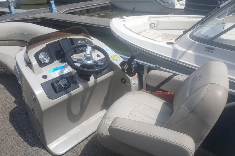 Slide: The Image of 2023 Cypress Cay Seabreeze 232 boat helm with steering wheel and captain's chair. - 6