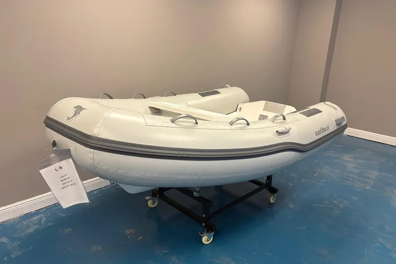Slide: The Image of 2024 Caribe L-9 inflatable boat displayed indoors with contact information. - 2